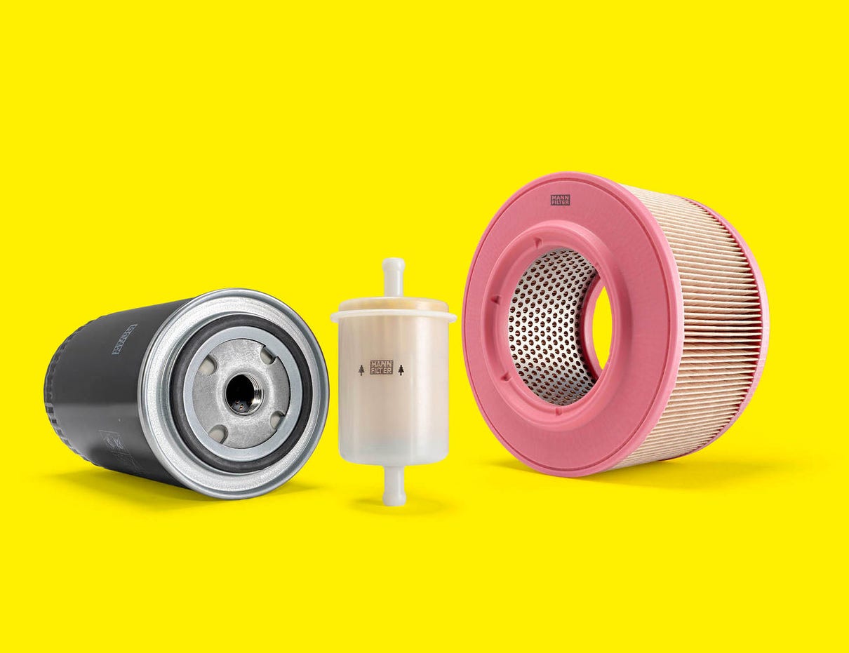 A selection of genset filters, including air and fuel filters, displayed on a yellow background