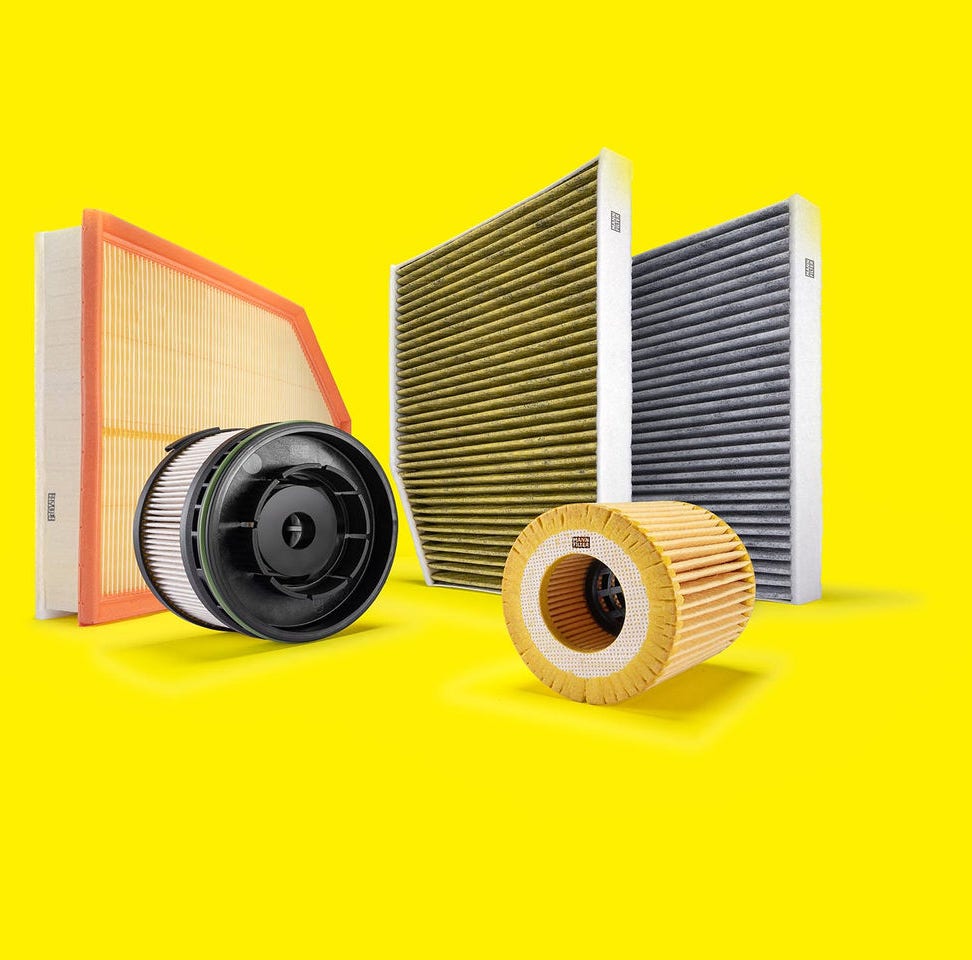 Autofilter von MANN-FILTER, einschließlich Luft-, Innenraum- und Ölfilter, auf gelbem Hintergrund