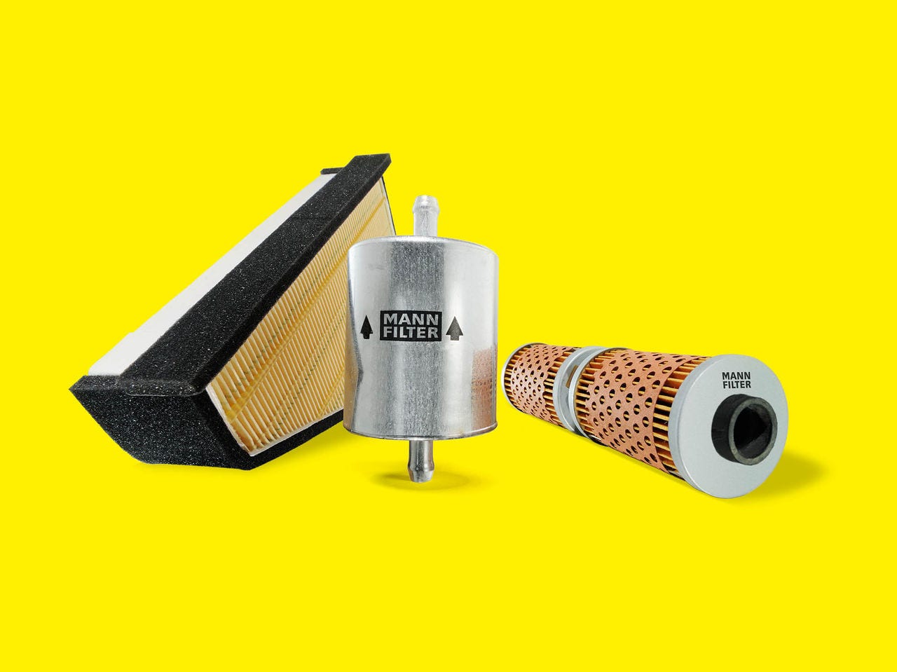 A variety of motorcycle filters from MANN-FILTER displayed on a yellow background