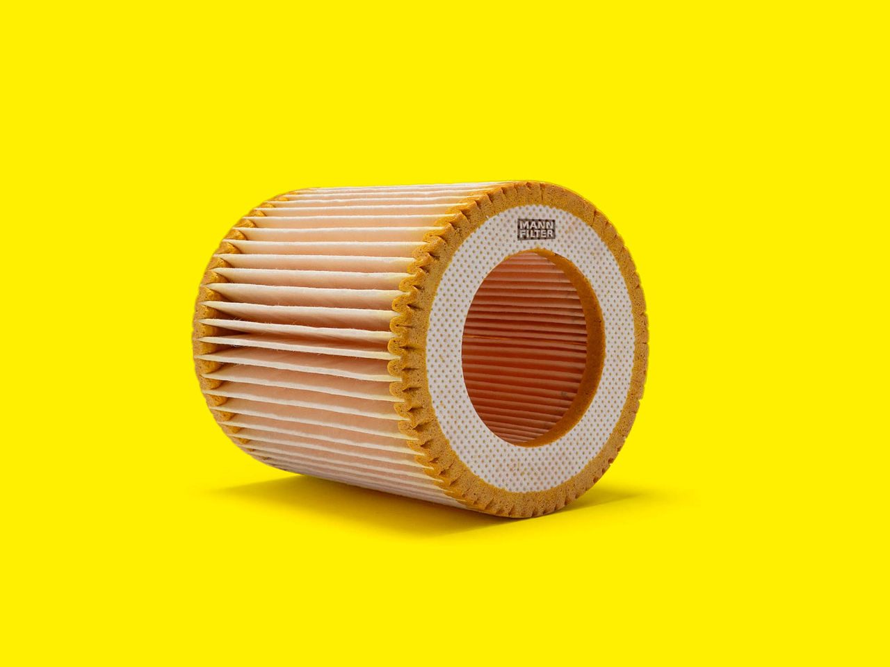 A round pleated air filter for compressors and vacuum pumps with orange and white accents