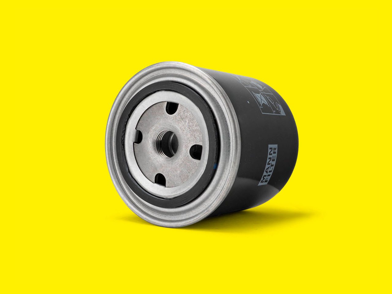 A black and silver coolant filter for material handling equipment displayed on a yellow background