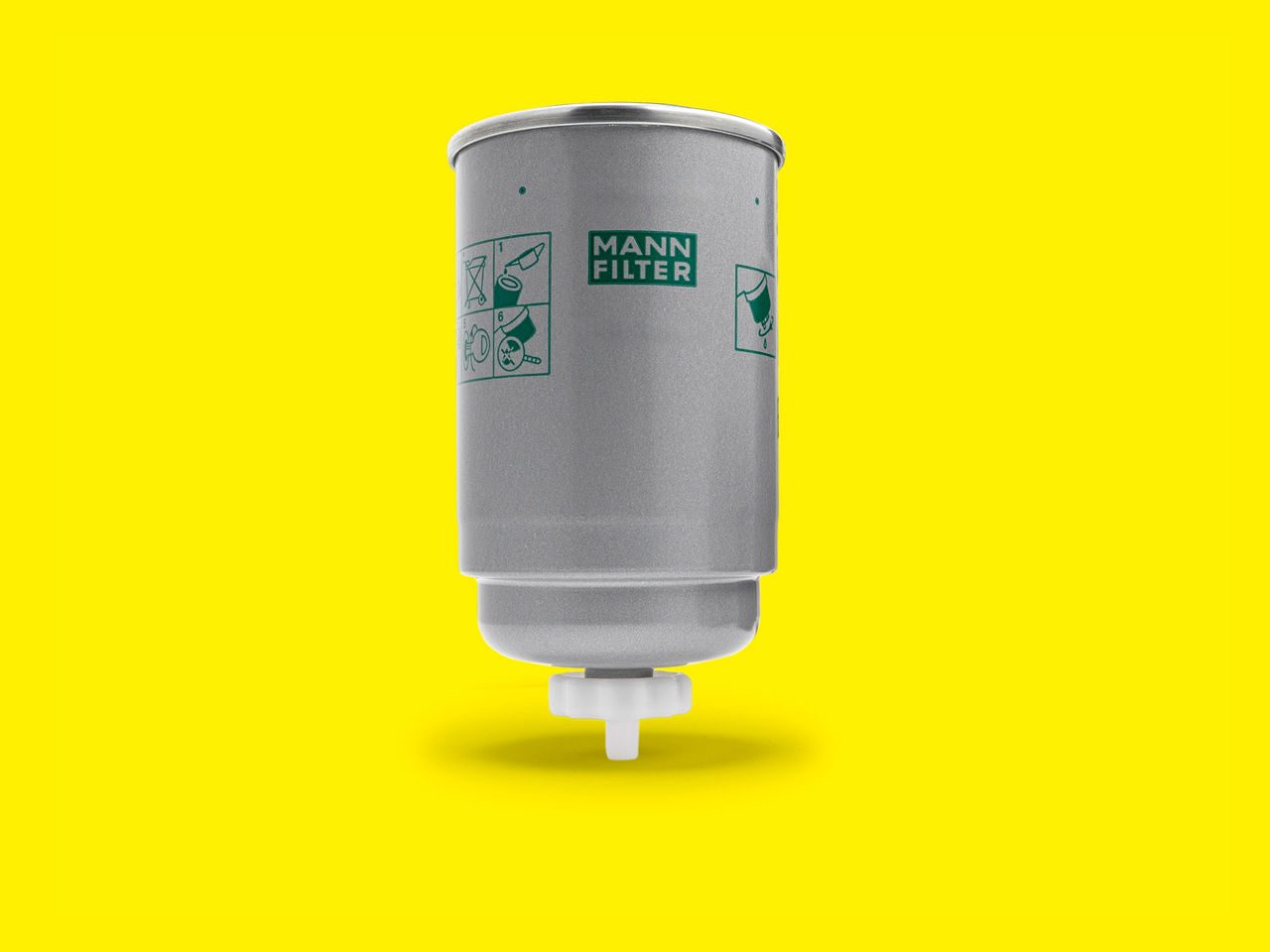 A silver fuel filter for compressors with green labeling displayed vertically on a yellow background