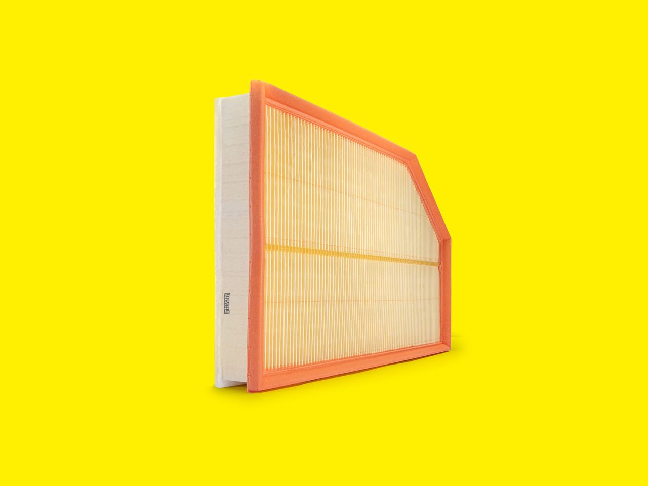 Orange-framed car air filter by MANN-FILTER with pleated element on a bright yellow background