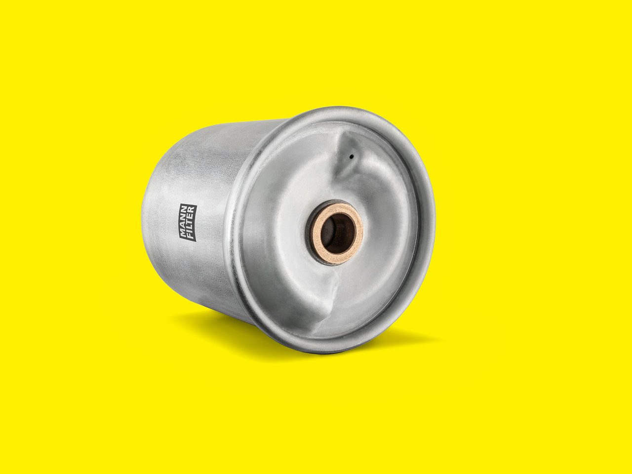 Silver MANN-FILTER centrifuge rotor with a threaded center on a bright yellow background