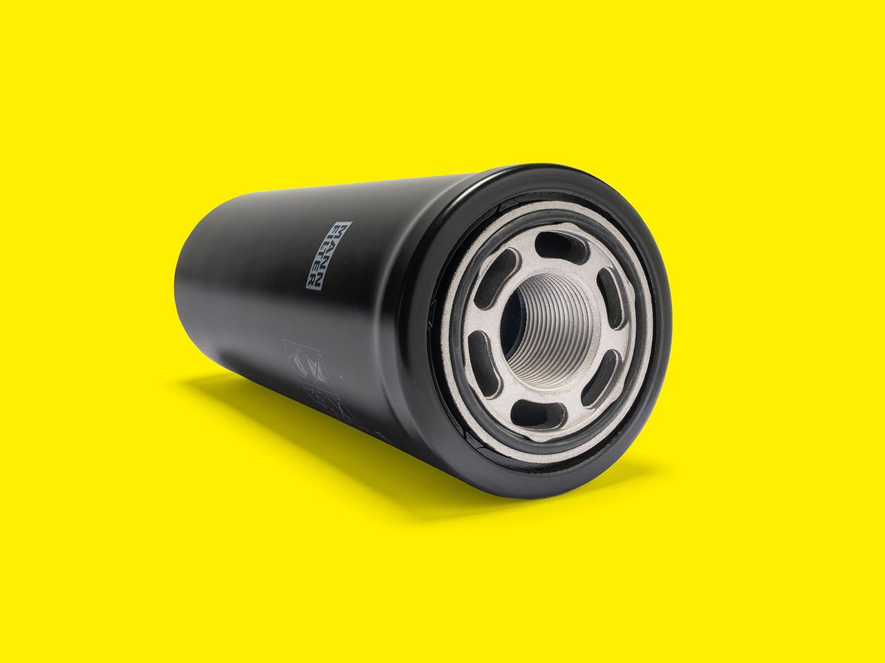 MANN-FILTER transmission oil filter with threaded metal base on a bright yellow background