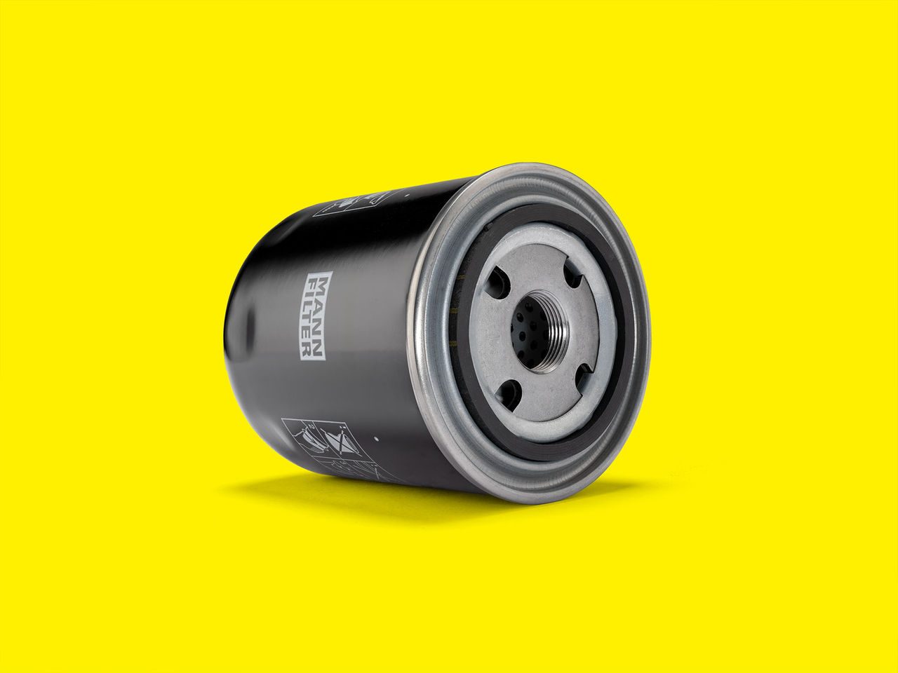 MANN-FILTER transmission oil filter with a yellow background, for trucks and buses