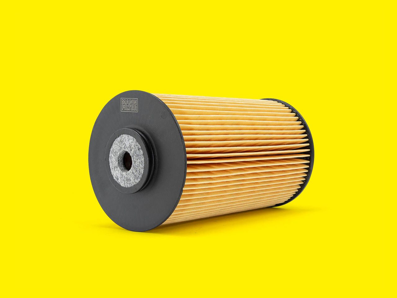 A pleated MANN-FILTER marine fuel filter with black caps displayed on a bright yellow background