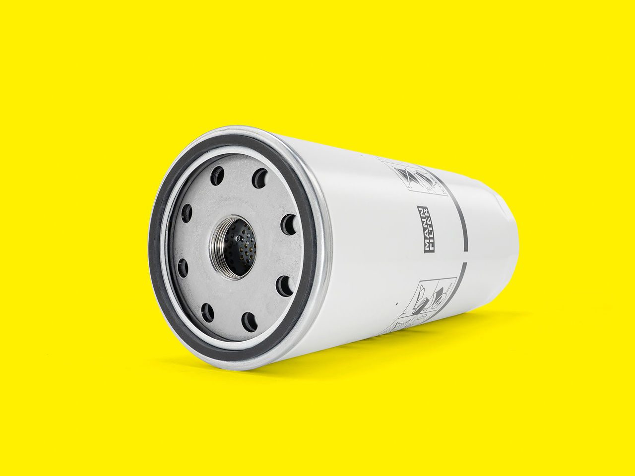 A white and silver MANN-FILTER marine oil filter displayed vertically on a yellow background