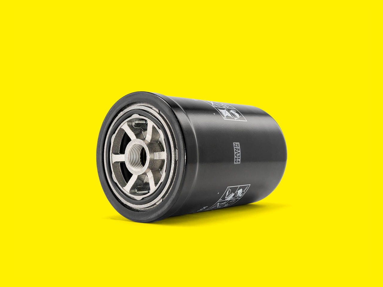 A black and silver transmission oil filter for forklifts on a yellow background