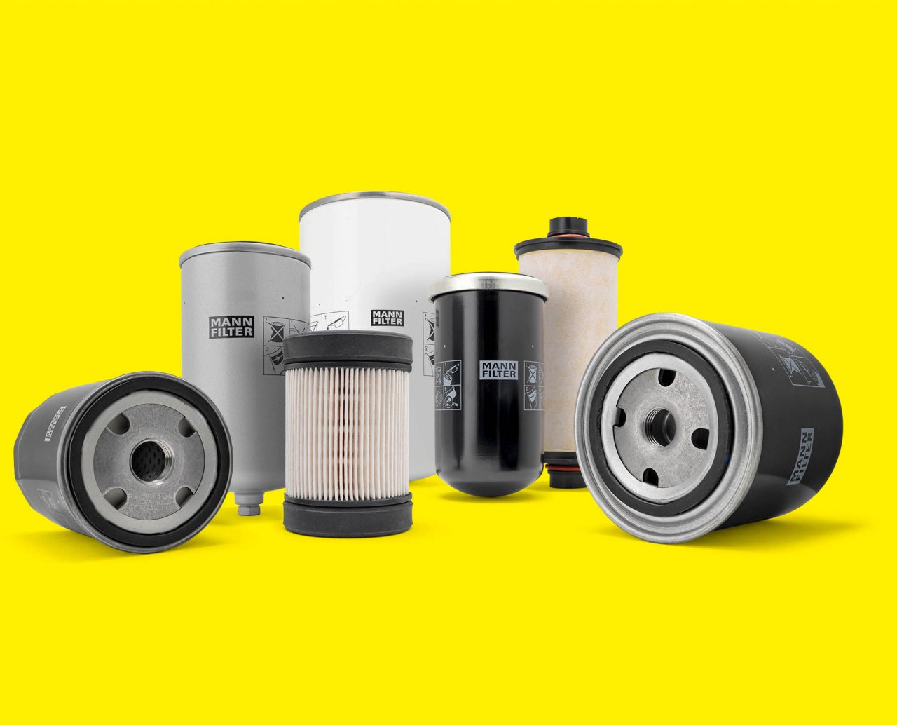 A selection of filters from MANN-FILTER for industrial engines displayed on a yellow background